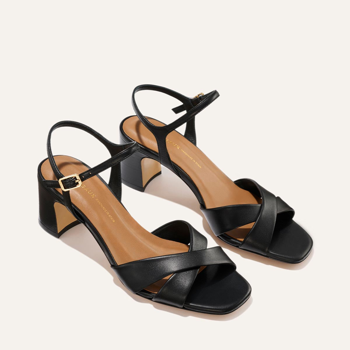 The Paloma Sandal - Black Nappa by Margaux, featuring open toes, block heels, crisscross straps, and ankle buckles, is displayed on a light background.