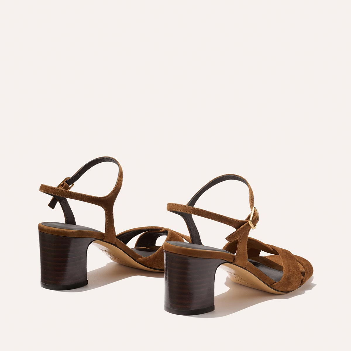 The Paloma Sandal by Margaux in nutmeg suede features open toes, leather ankle straps, and 2.5-inch stacked wooden block heels—an ideal everyday sandal, beautifully displayed on a light background.