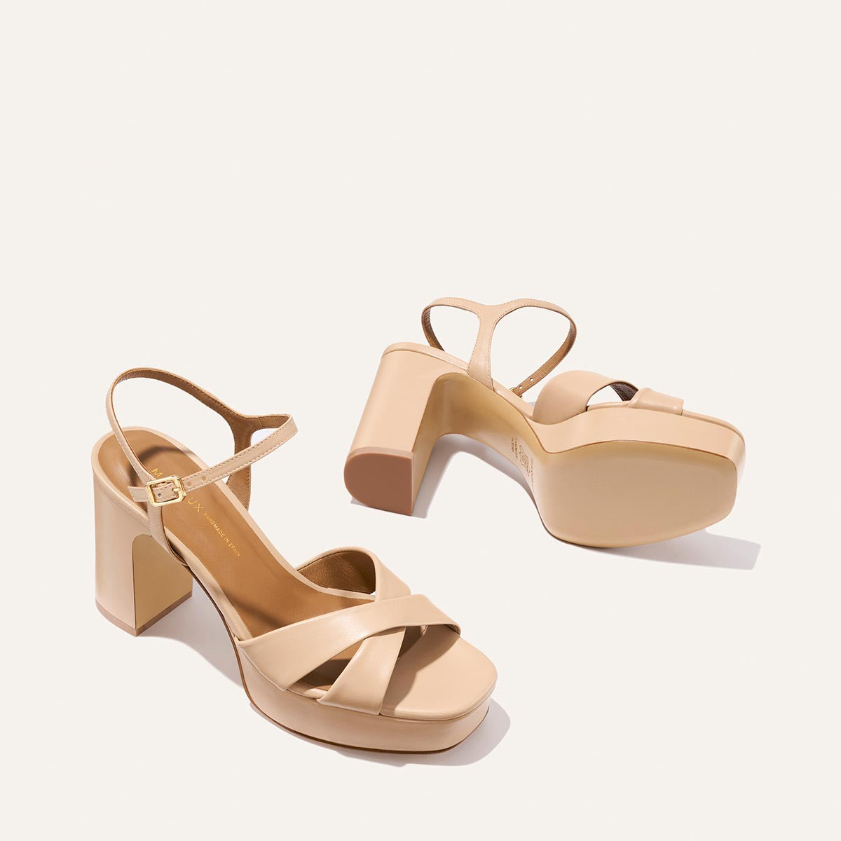 The Paloma Platform - Dune Nappa by Margaux: beige block-heeled sandals with padded platform and ankle straps. One stands upright, the other shows the sole—ideal for all-night wear.