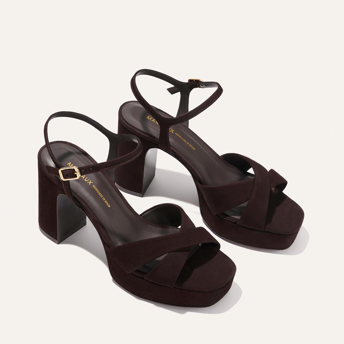 The Paloma Platform - Espresso Suede by Margaux: dark brown heeled event sandals with thick block heels, a padded platform for comfort, crisscross toe and ankle straps with gold buckles, shown on a light background.
