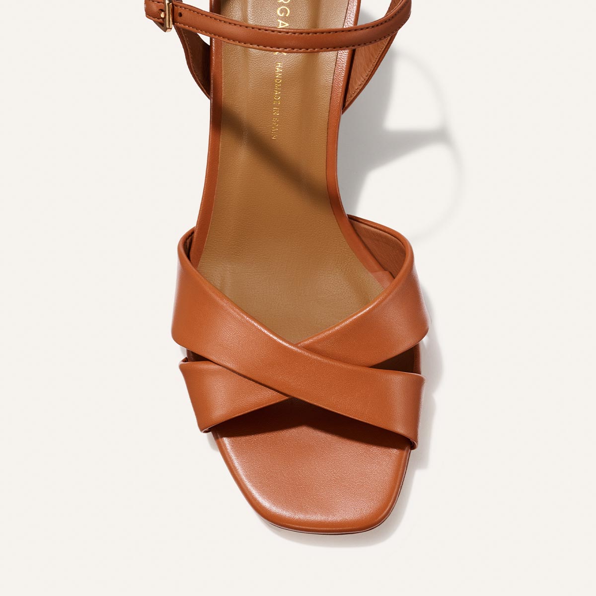 Top view of Margaux's The Paloma Sandal in Saddle Nappa: a brown sandal with wide, crisscross leather straps, square toe, ankle strap, and lightly cushioned insole.