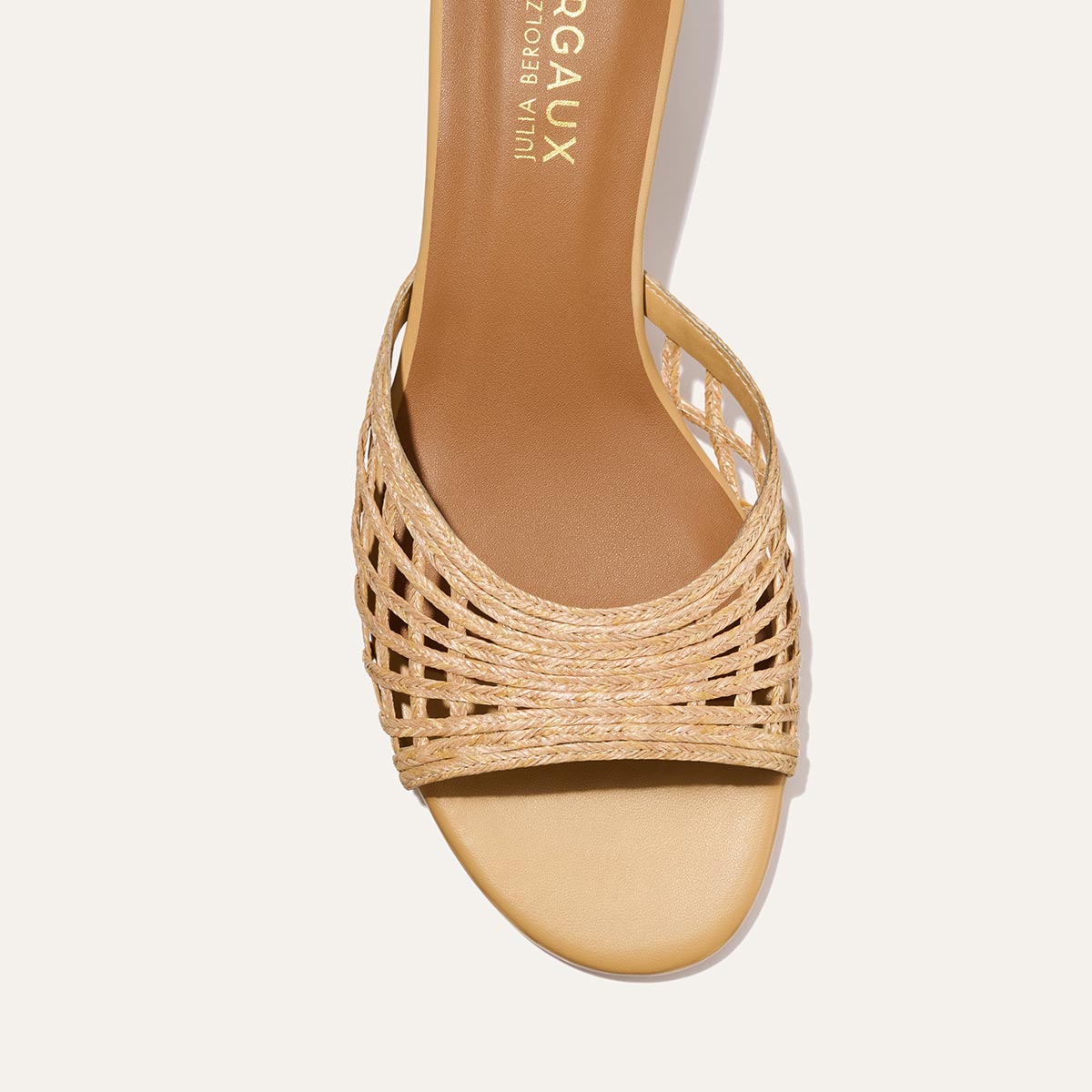 Beige sandal with woven design on a white background