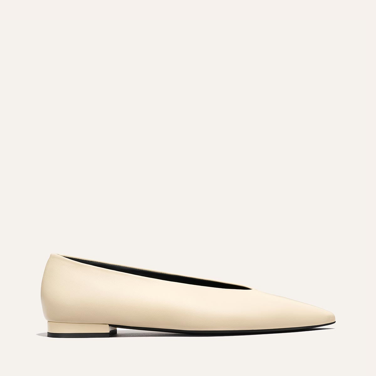 The Parra - Ivoire Nappa by margaux-development is a minimalist, cream flat with a pointed toe and low square heel, shown from the side on a plain light background.