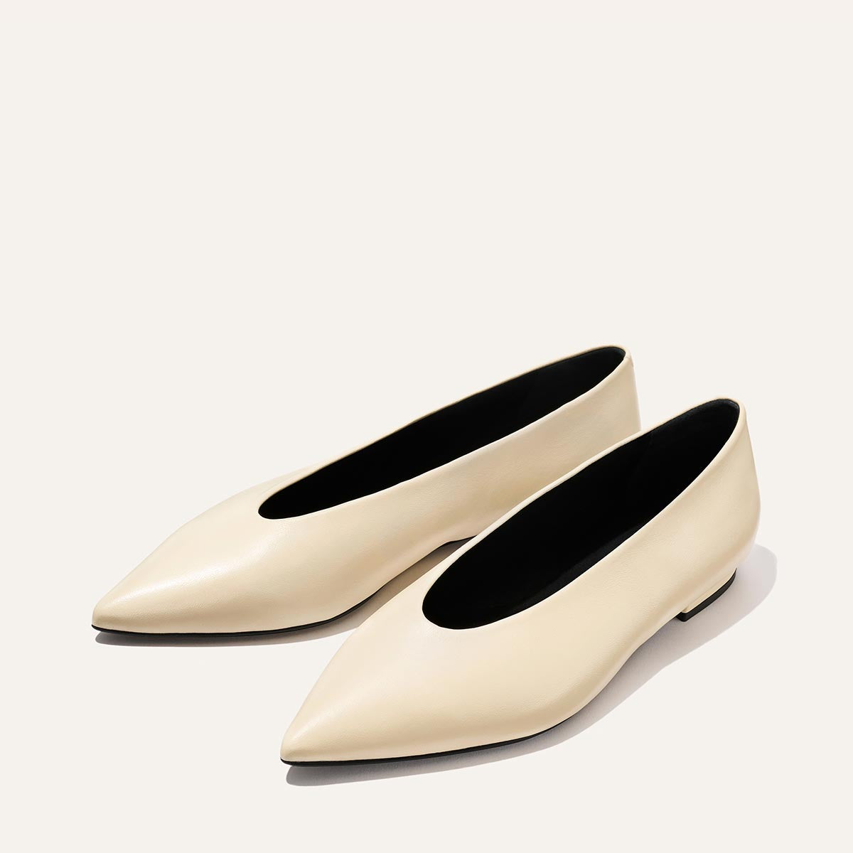 The Parra - Ivoire Nappa by margaux-development: cream-colored, pointed-toe flats with a sleek, minimalist design, shown on a light background.