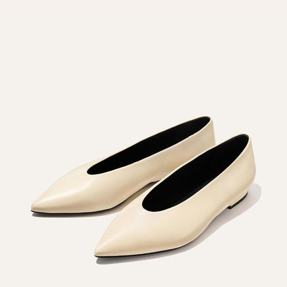 The Parra - Ivoire Nappa by margaux-development: cream-colored, pointed-toe flats with a sleek, minimalist design, shown on a light background.
