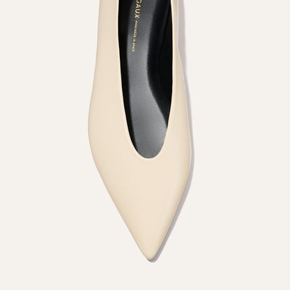 Top view of The Parra - Ivoire Nappa by margaux-development: a single beige pointed-toe shoe with a black insole, displayed against a light background.