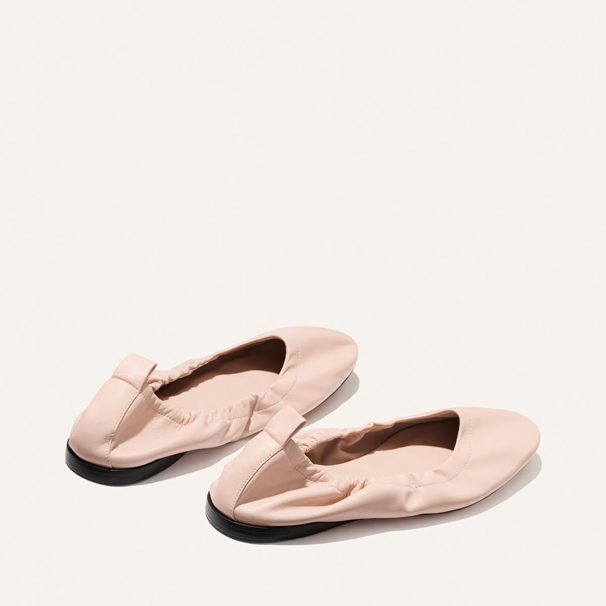 Pair of pink loafers on a white background