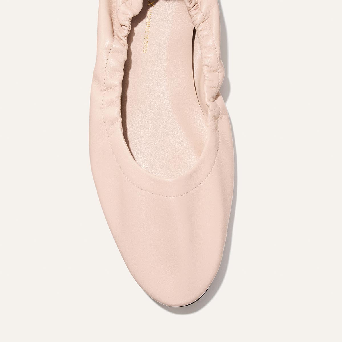 Pink ballet flat shoe on a white background