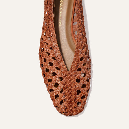 Top view of Margaux's The Woven Paz - Saddle Leather flat, featuring a pointed toe, handwoven brown leather with intricate cut-outs, highlighting its luxuriously soft texture and detailed craftsmanship.