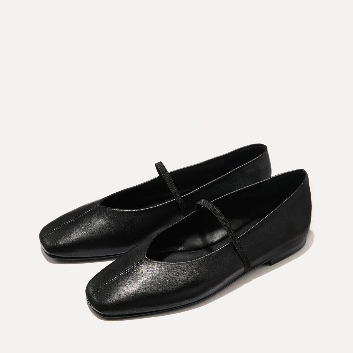 The Phoebe in smooth Black Nappa leather, a ballet flat with a squared off toe, high vamp and elastic Mary Jane strap.