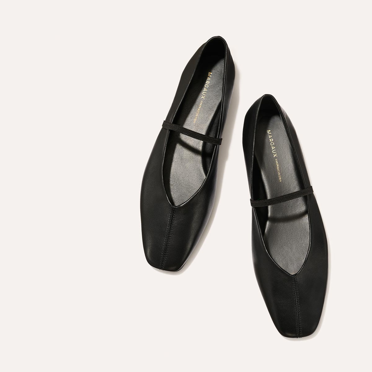 The Phoebe in smooth Black Nappa leather, a ballet flat with a squared off toe, high vamp and elastic Mary Jane strap.