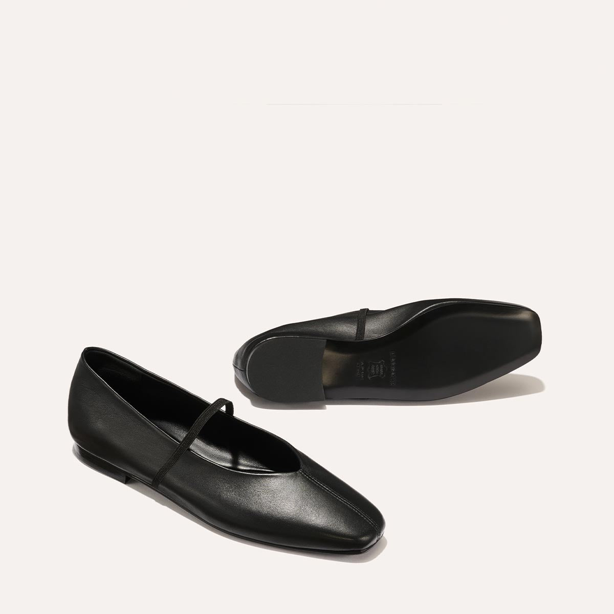 The Phoebe in smooth Black Nappa leather, a ballet flat with a squared off toe, high vamp and elastic Mary Jane strap.