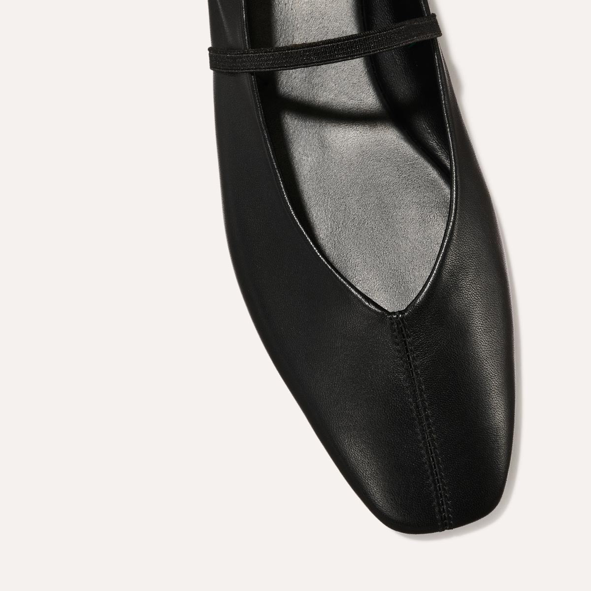 The Phoebe in smooth Black Nappa leather, a ballet flat with a squared off toe, high vamp and elastic Mary Jane strap.