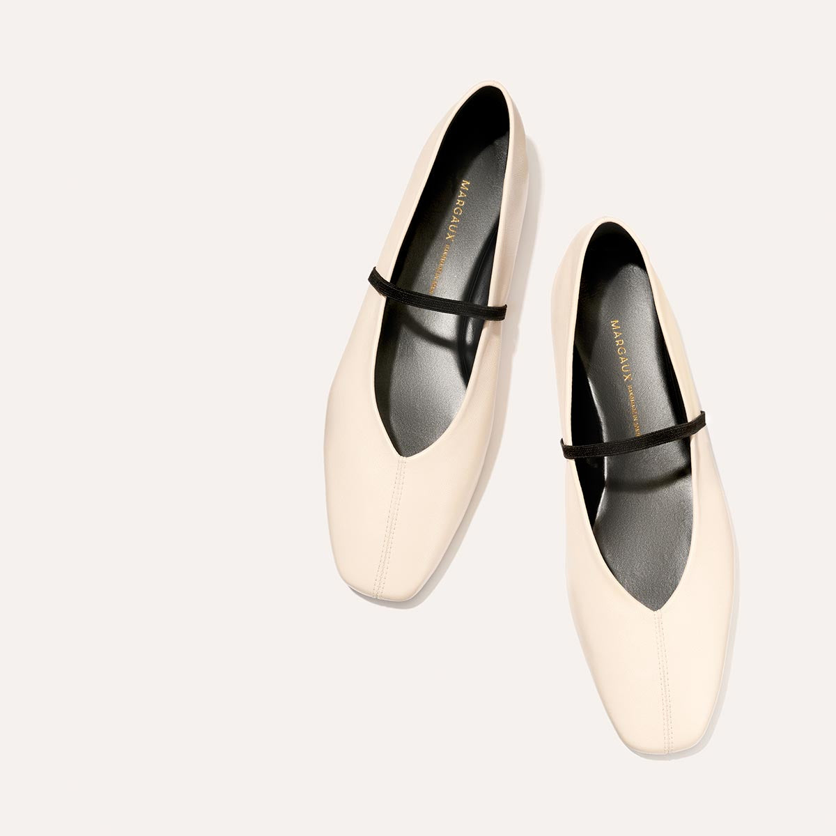 The Phoebe in smooth Bone Nappa leather, a ballet flat with a squared off toe, high vamp and elastic Mary Jane strap.