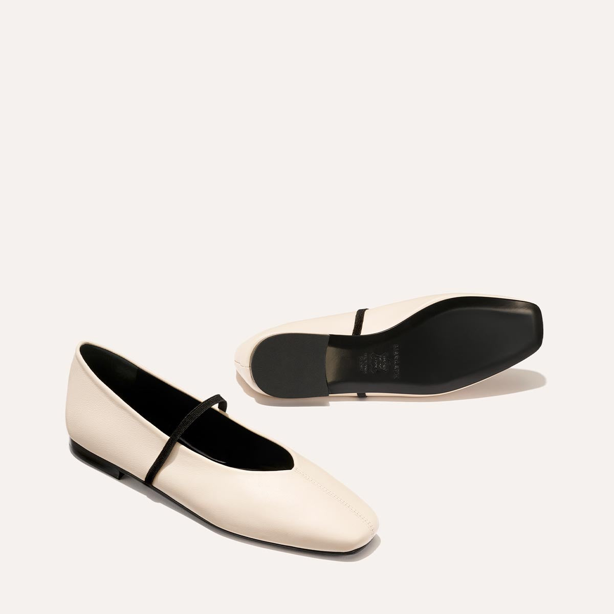 The Phoebe in smooth Bone Nappa leather, a ballet flat with a squared off toe, high vamp and elastic Mary Jane strap.