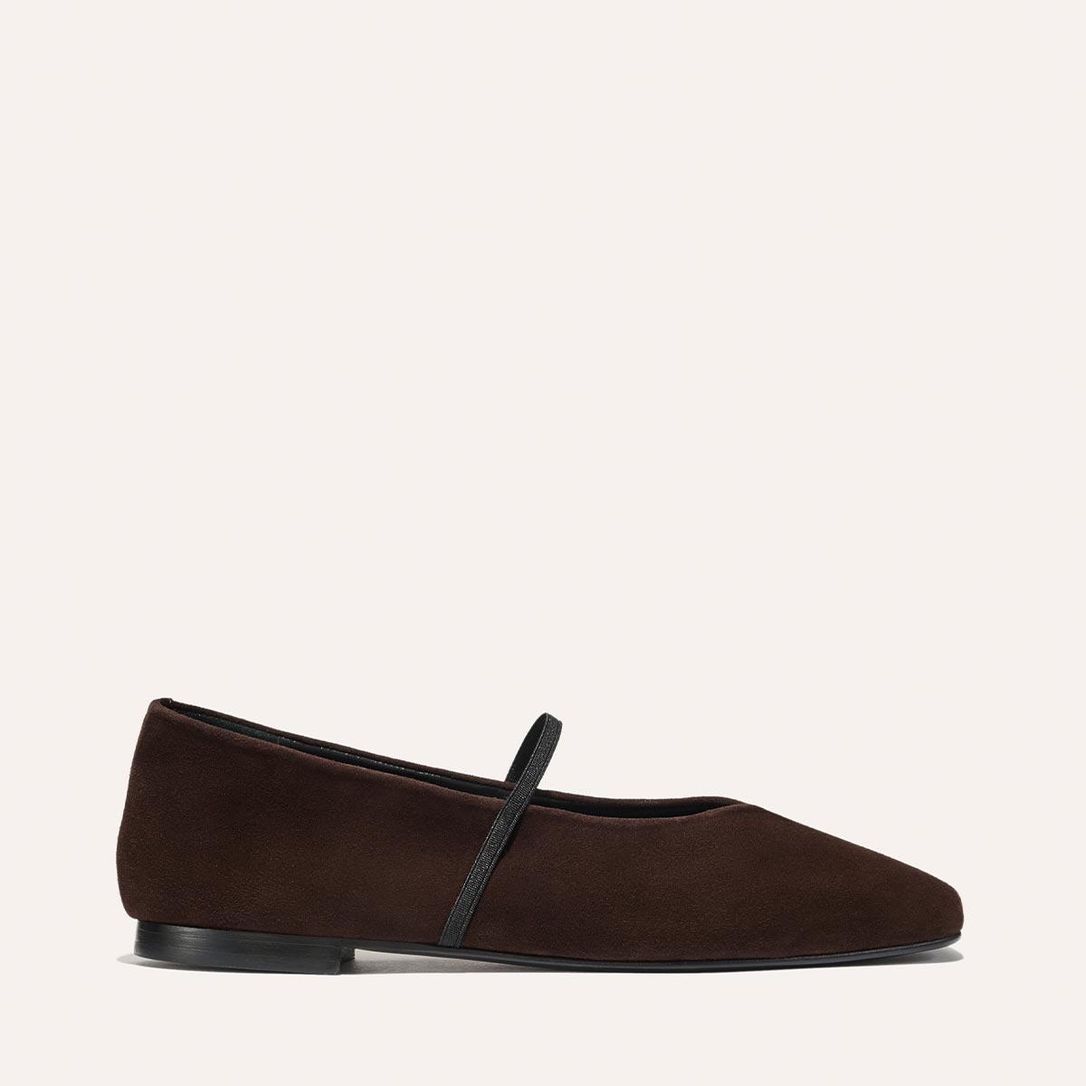 The Phoebe - Espresso Suede by margaux-development is a dark brown suede ballet flat with a black instep strap and low black heel, crafted with sacchetto construction for softness. Shown against a light background.