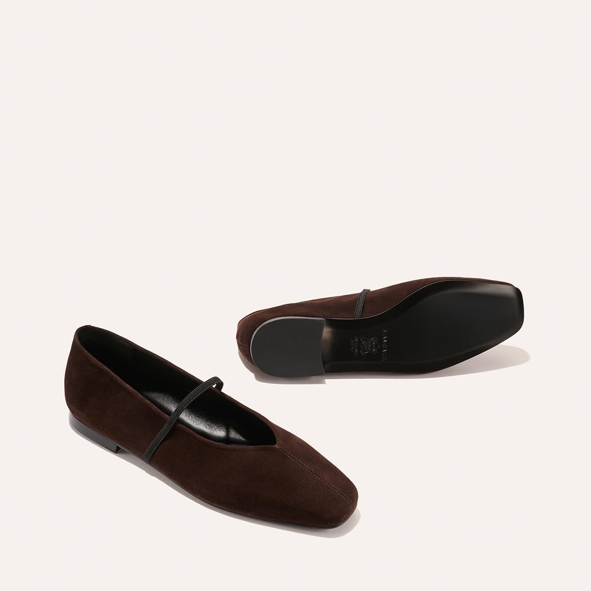 The Phoebe - Espresso Suede by margaux-development: a pair of dark brown suede ballet flats with sacchetto construction and a thin top strap, displayed on a plain light background—one upright, the other on its side.