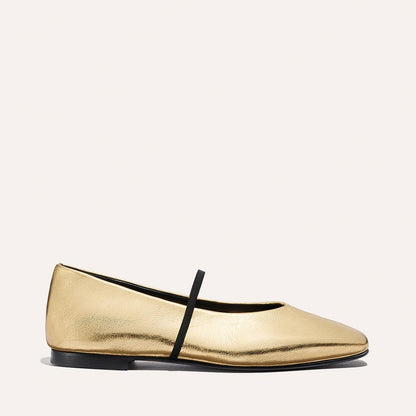 The Phoebe - Gold Crinkle Nappa by margaux-development is a single gold deconstructed flat with a rounded toe, black sole, and a thin black elastic strap across the top, displayed on a neutral background.