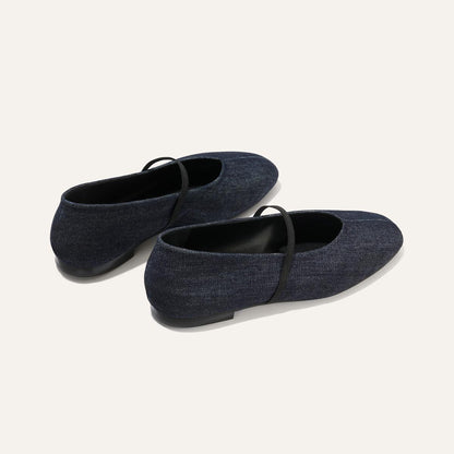 The Phoebe - Indigo Denim by margaux-development: dark blue denim ballet flats with sacchetto construction and thin black elastic straps, shown from the back and side against a light background.