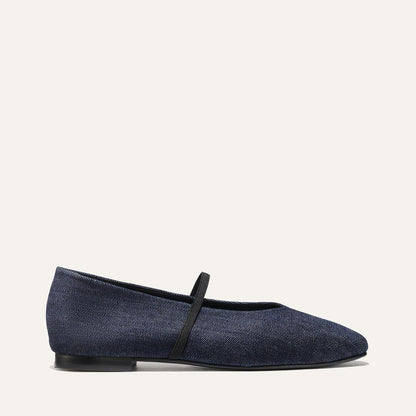 The Phoebe - Indigo Denim by margaux-development is a single deconstructed flat in dark blue denim with a thin black strap across the top, displayed in profile against a plain light background.