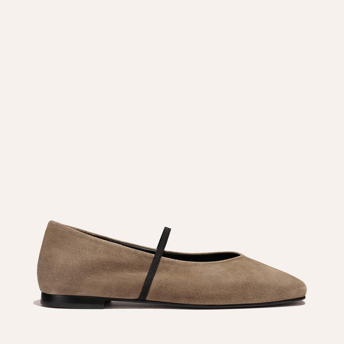 The Phoebe - Mushroom Suede by Margaux is a taupe suede ballet flat featuring a rounded toe, slim black sole, and thin black strap across the top, shown against a plain light background.