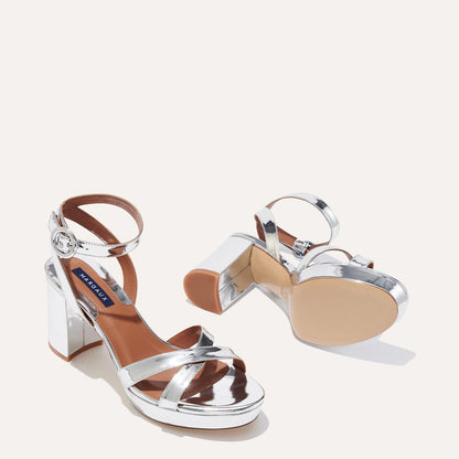 The Platform Sandal in shiny Silver Mirror, featuring a sleek ankle strap, perfectly placed straps across the toes and a comfortable 3.5-inch block heel.