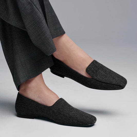 Grey flannel The Portia Loafer with a low heel worn with dark trousers.