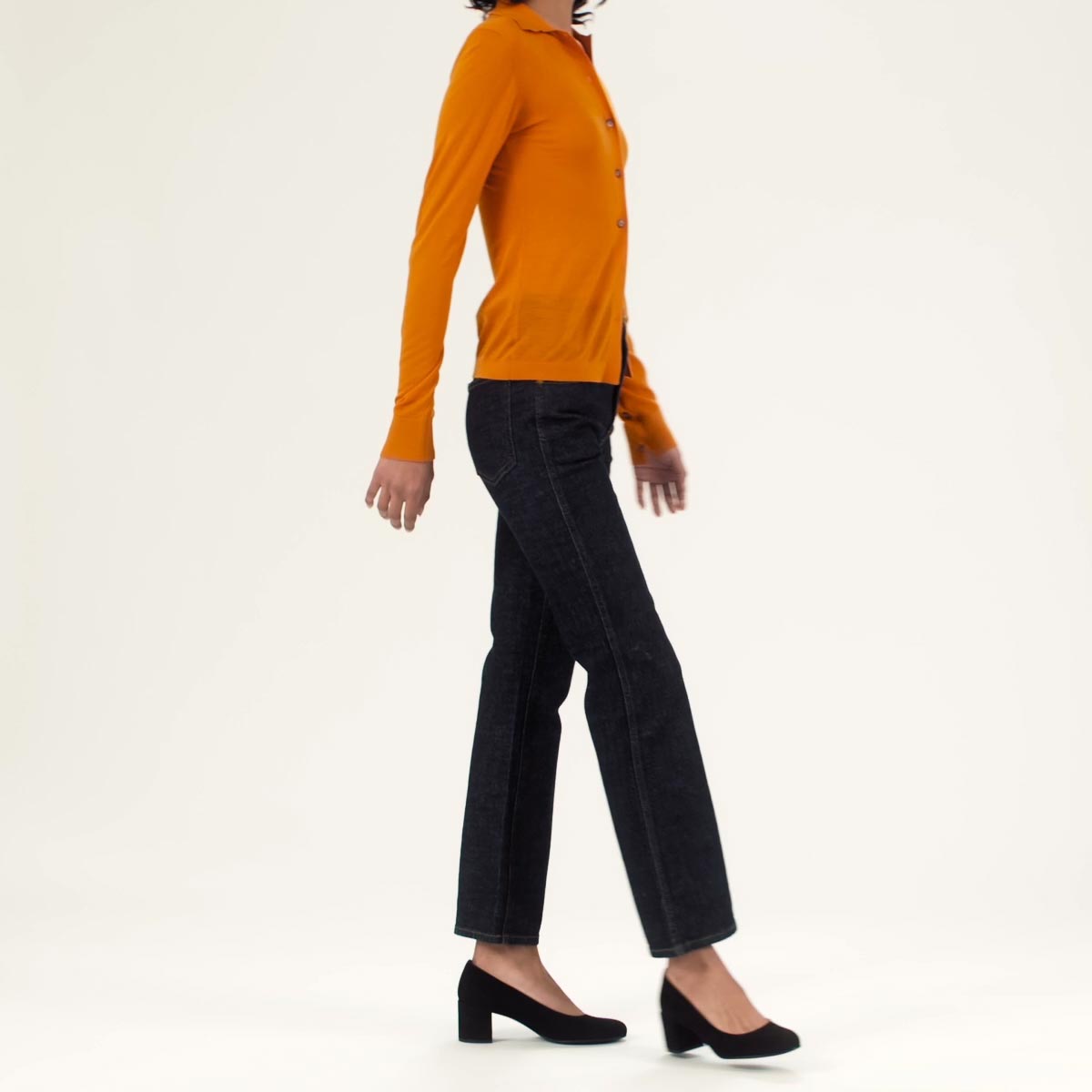 The Heel in Black shown with black straight leg jeans and an orange cardigan.