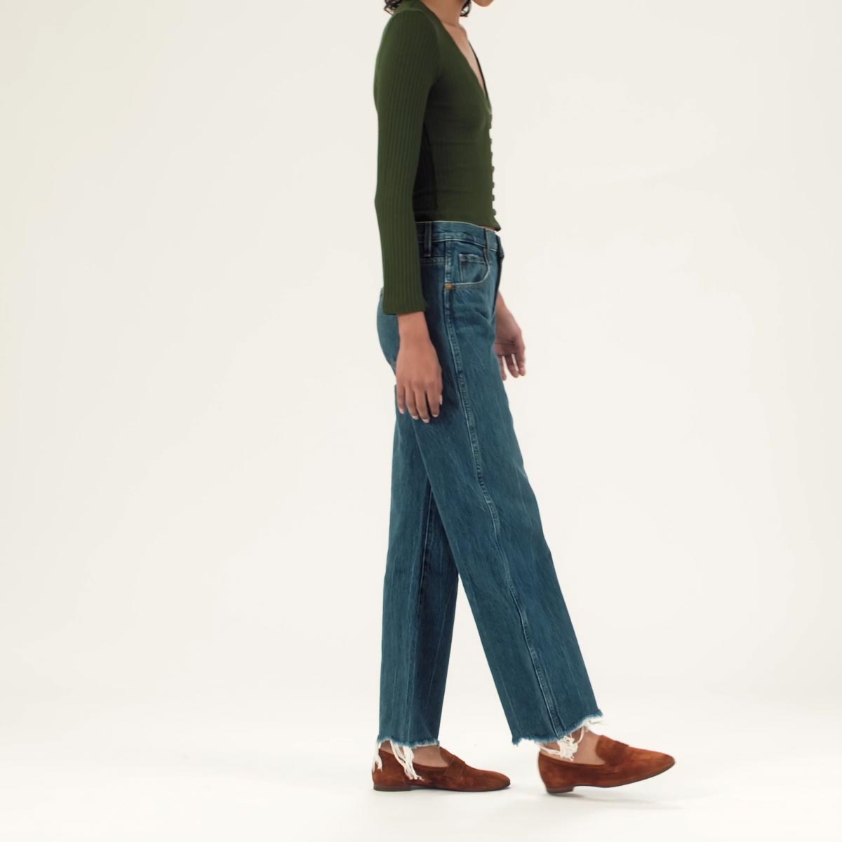The Penny in Caramel shown on model styled with straight leg raw hem denim and an olive green knit long sleeve top. 