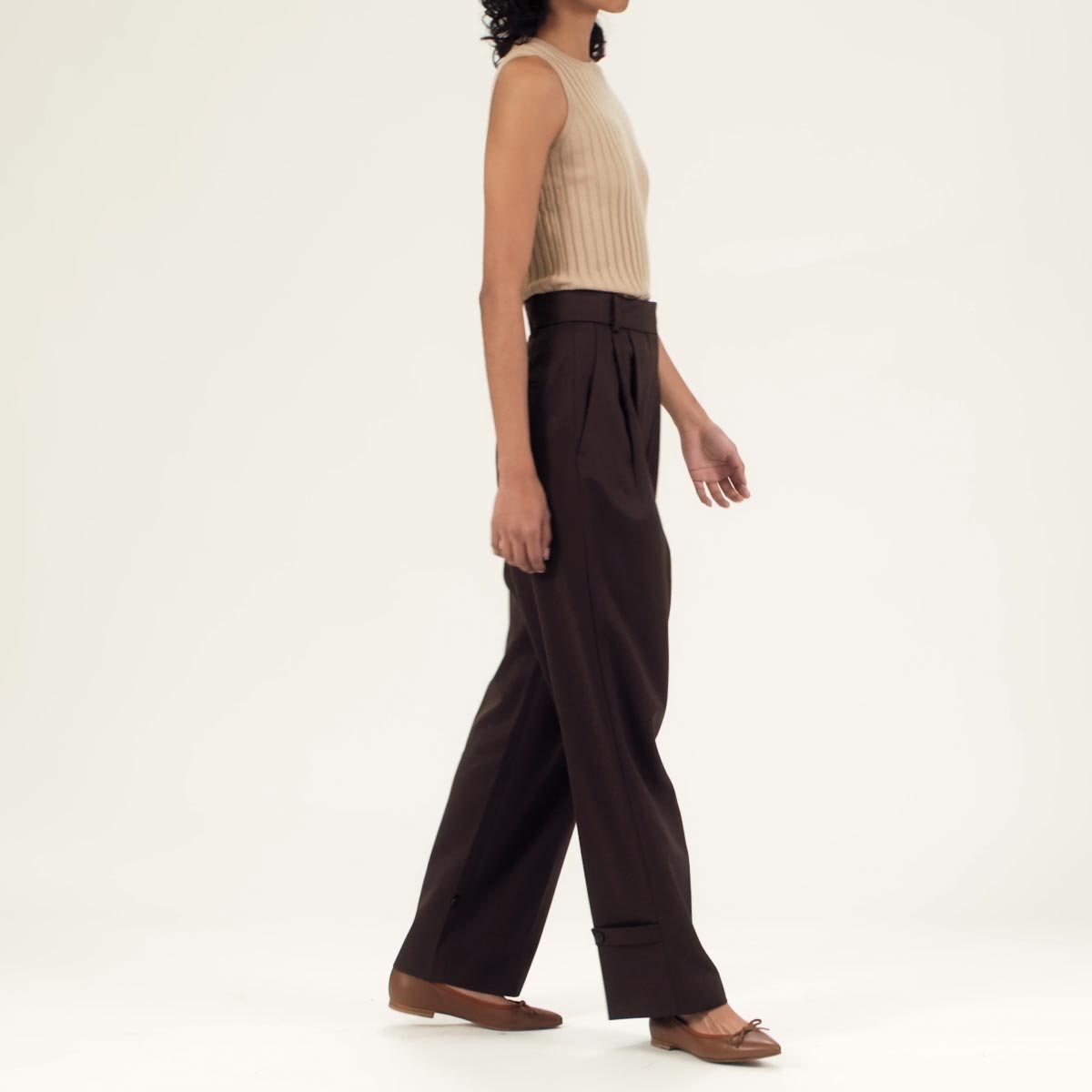 The Pointe in Saddle Nappa shown on model styled with chocolate brown dress pants and a beige sleeveless blouse.