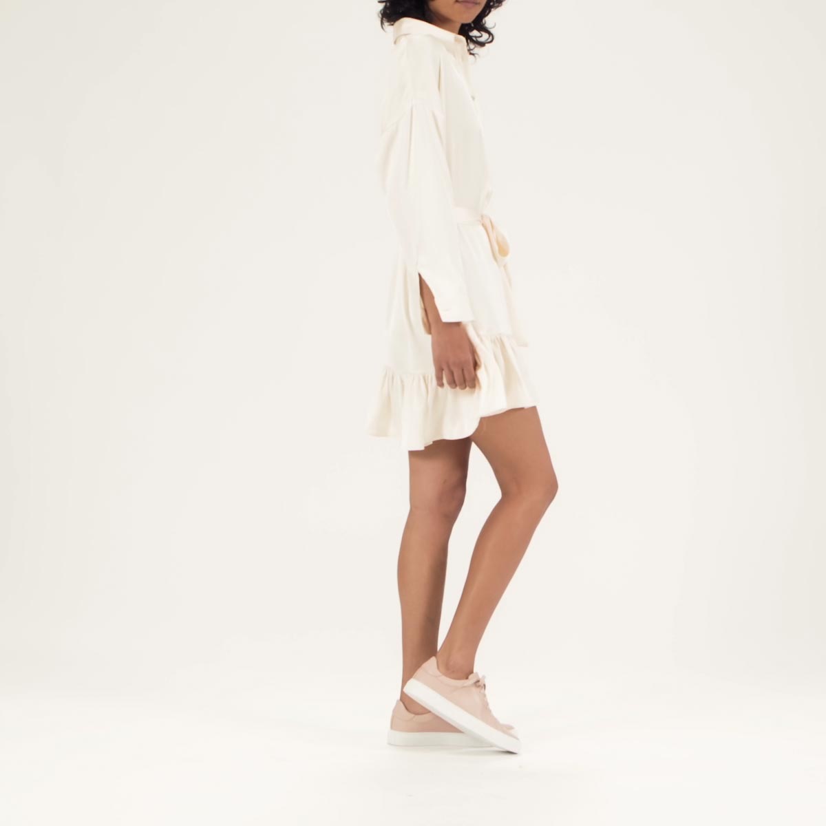The Sneaker in Rose Calf shown on model styled with a white ruffle hem shirt dress.