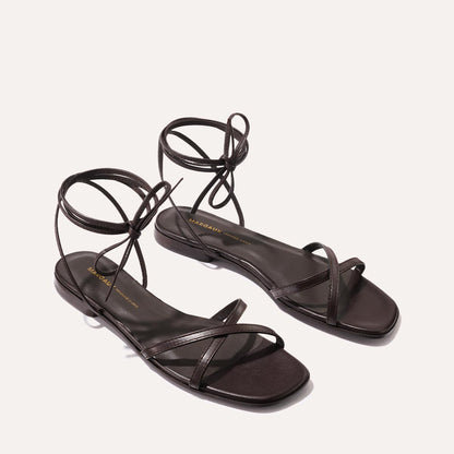 The Wrap Sandal - Espresso Nappa by Margaux features dark brown strappy styling with thin ankle ties, showcased on a neutral background—ideal for versatile summer looks.