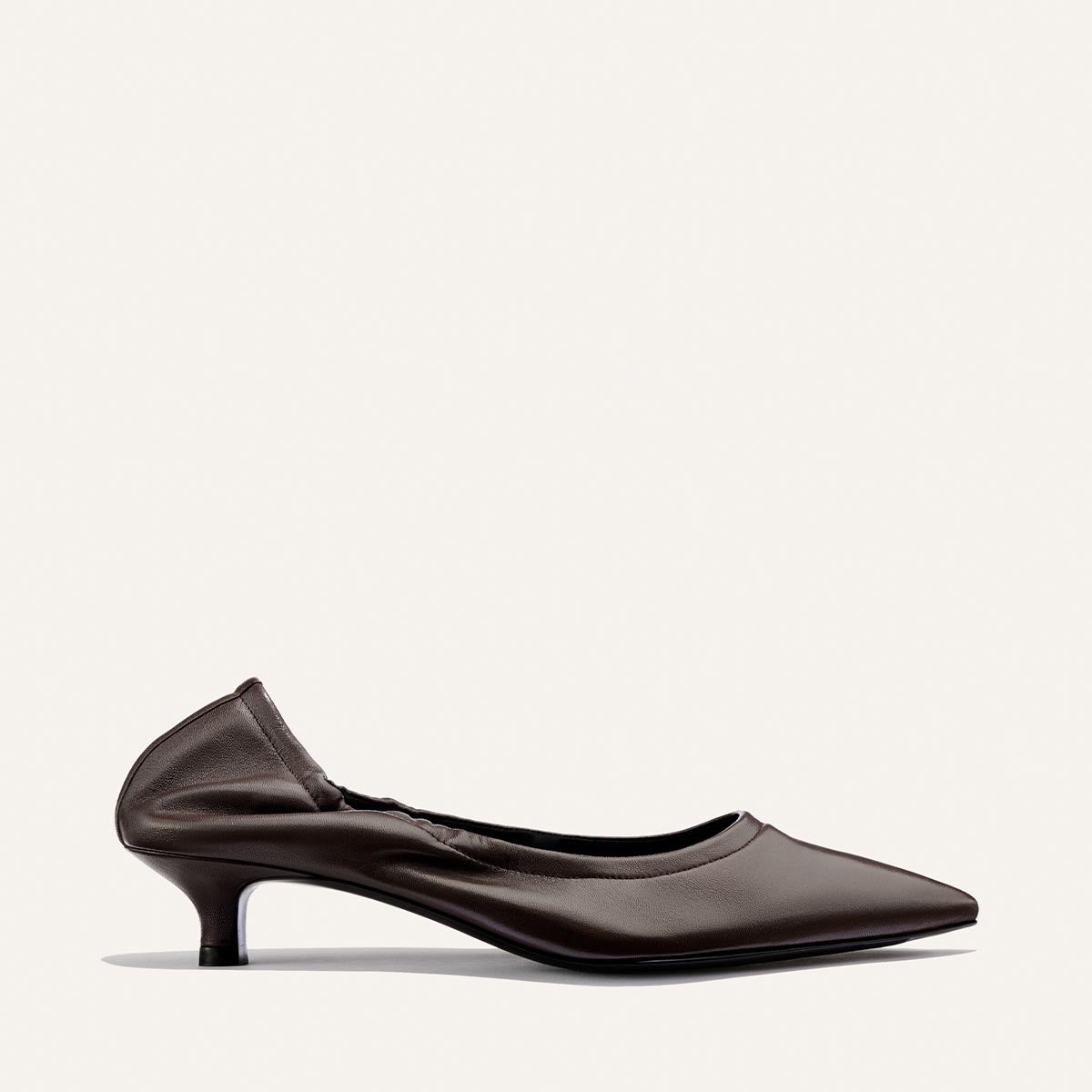 A single chic heel, The Roma 40 in Espresso Nappa by Margaux, features a pointed-toe design and subtle ruched detailing at the back, photographed against a plain light background.