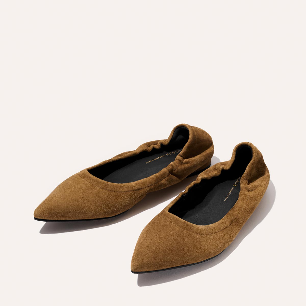 The Roma - Cedar Suede by Margaux: brown suede pointed-toe ballet flats with elasticized sides and black insoles, displayed on a light background.