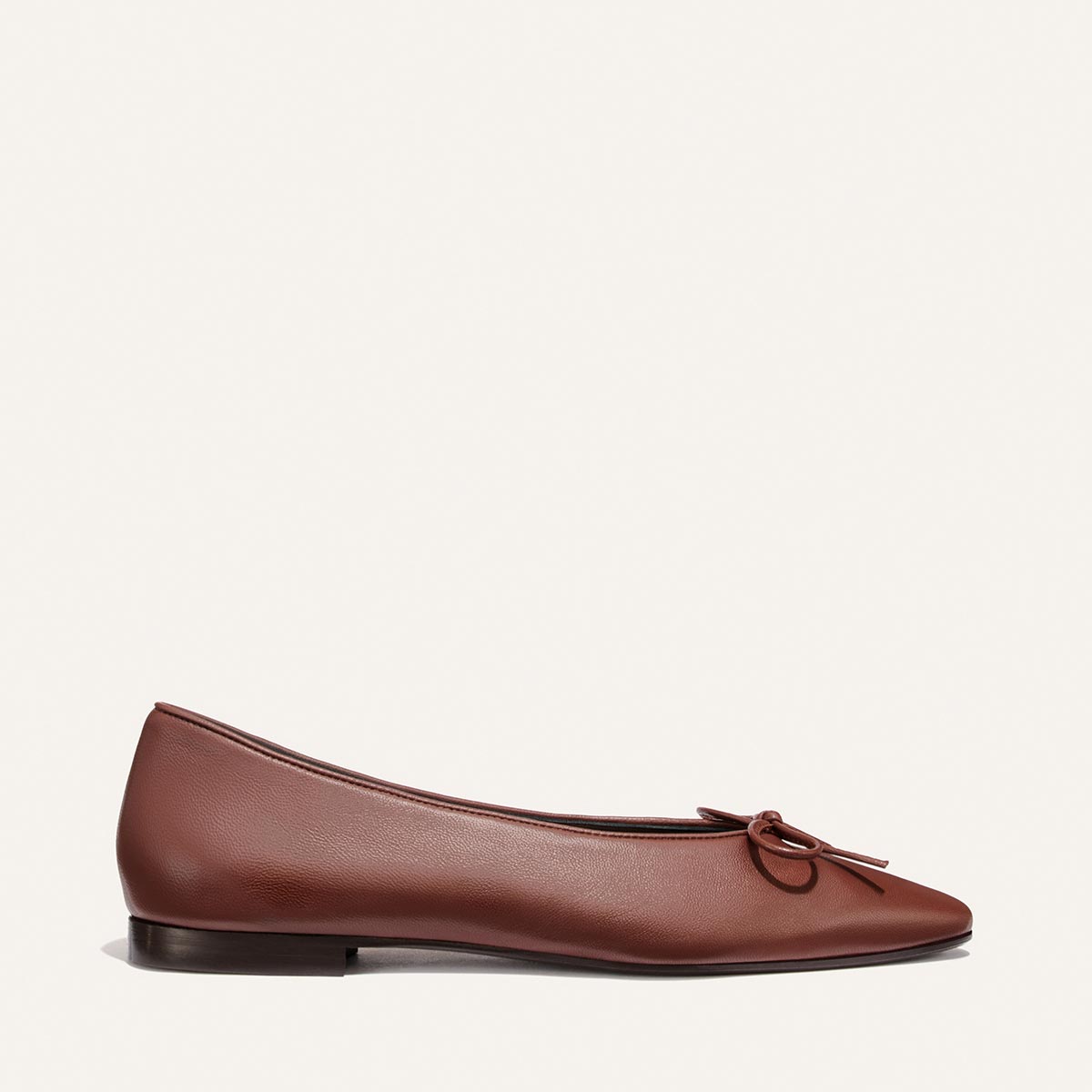 The Salamanca - Brandy Nappa by Margaux: a brown leather pointed-toe flat with a small bow, low heel, and simple, buttery soft design, shown against a white background.