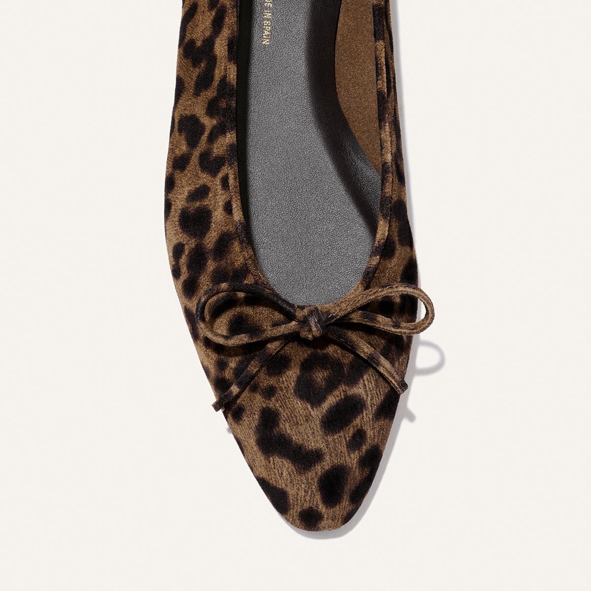 Close-up of The Salamanca - Brown Leopard Suede by Margaux: a pointed-toe flat in brown and black leopard suede, featuring an unlined construction and a small bow detail on the front.