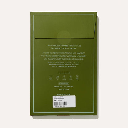 Olive green packaging with a flap and centered gold text showcases Margaux’s Semi-Sheer Tights - Black. A white barcode label with product info appears at the bottom, while a light beige background complements the Margaux boots collection.