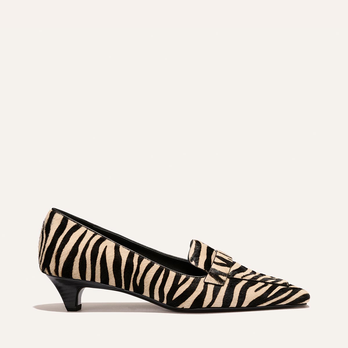The Sigrid - Tan Zebra Haircalf pointed-toe kitten heel loafer in a tan and black zebra print pattern.