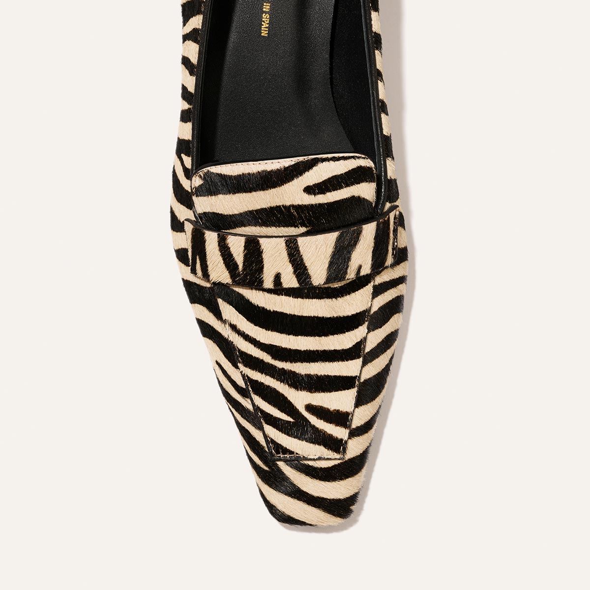 The Sigrid - Tan Zebra Haircalf pointed-toe loafer in a tan and black zebra-striped pattern.