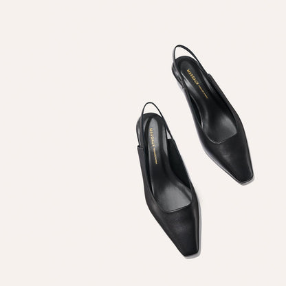 The Sofia Sling - Black Nappa by margaux-development: black snip-nose slingback heels with a low-cut front and branded insoles, displayed on a light, minimal background.