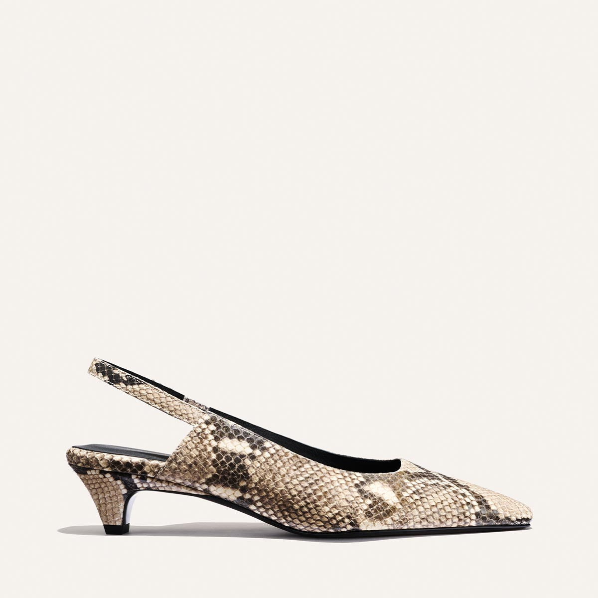 The Sofia Sling - Natural Python Embossed by Margaux is a beige and black snakeskin-patterned slingback featuring a snip nose, 1.5" low kitten heel, pointed toe, and black inner lining, displayed against a plain white background.