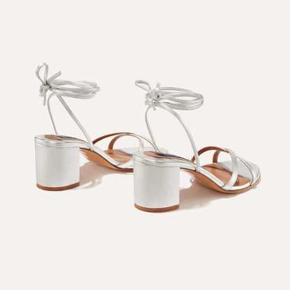 The Soho Sandal in Silver Nappa, featuring thin, flattering straps with a delicate ankle wrap, and a comfortable 2.5-inch block heel.