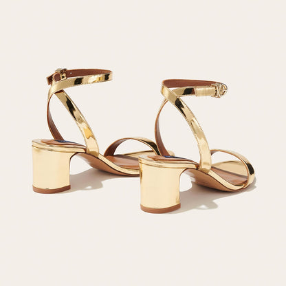 The Stella Sandal in shiny Gold Mirror, featuring a sleek strap across the toes and a comfortable 2.5-inch breasted heel.