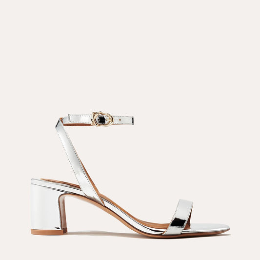 Margaux's classic and comfortable Stella Sandal in metallic silver patent leather with a perfectly placed strap and a walkable block heel