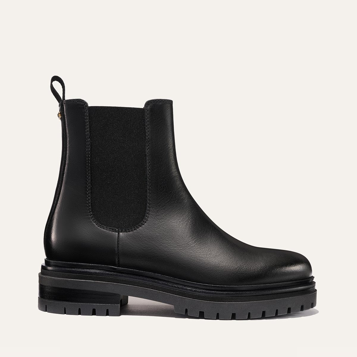 The West Chelsea Boot - Black Calf by margaux-development features black leather, elastic side panels, a back pull tab, and a thick lug sole, shown on a plain light background.