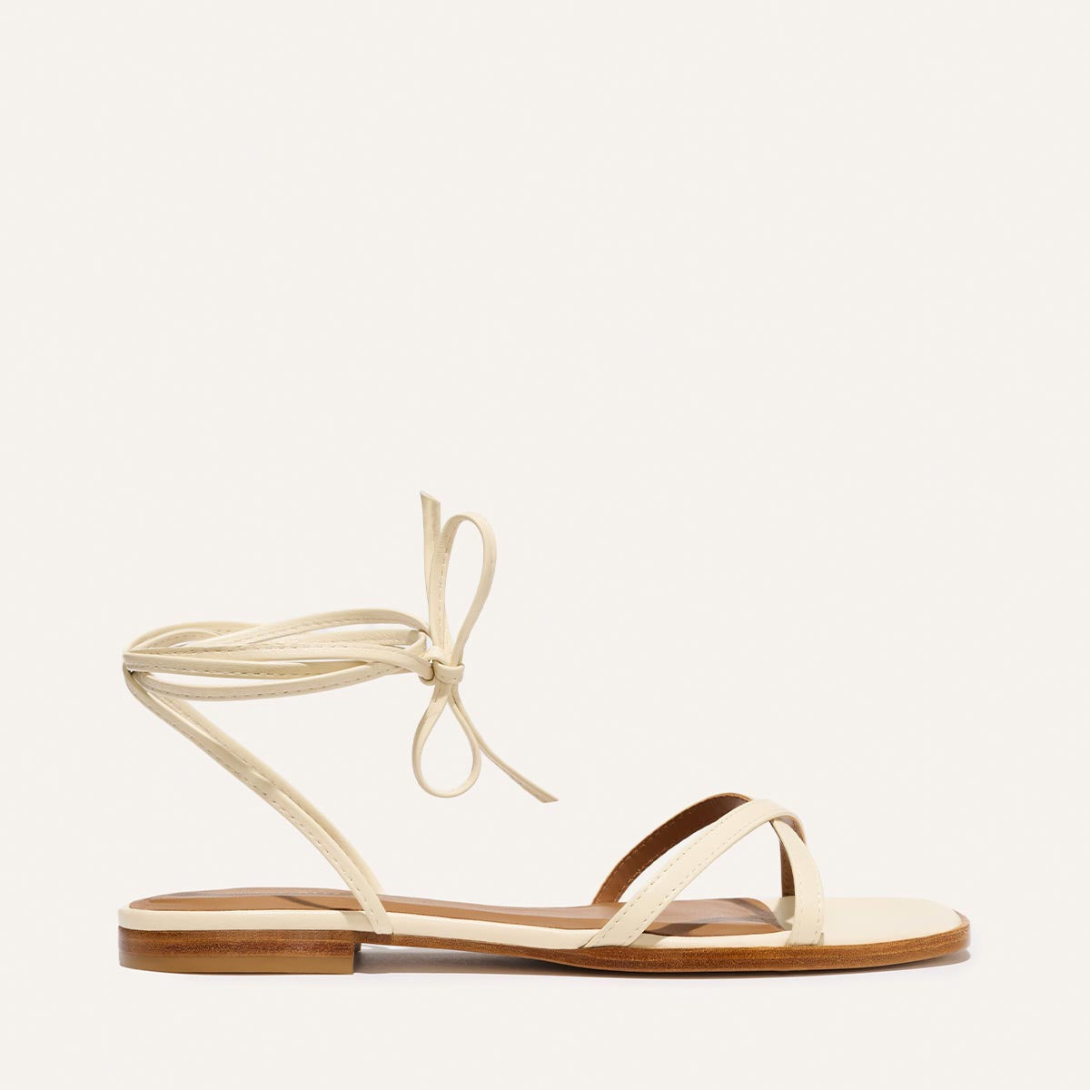 Beige sandal with a bow on a white background