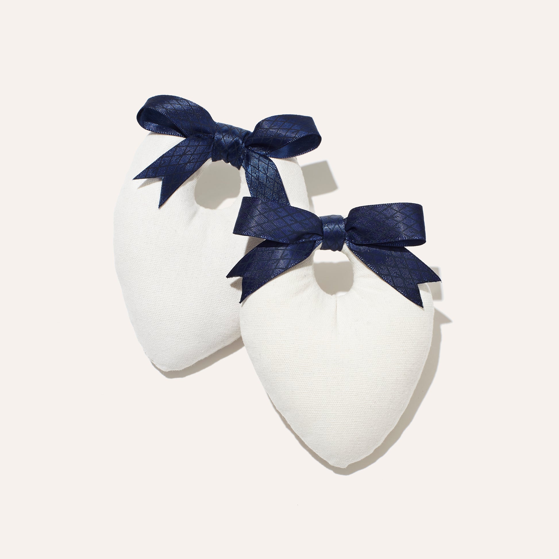 Canvas shoe shapers with navy satin bow for shoe storage and travel