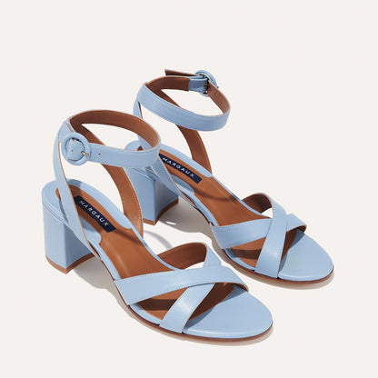 The City Sandal - Fog Nappa by margaux-development features light blue, open-toe block heels with crisscross and ankle buckle straps, cushioned insoles, tan inner soles, and a visible brand label on a light background.