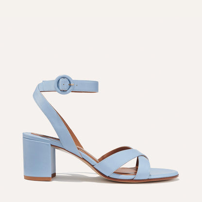 The City Sandal - Fog Nappa by margaux-development features light blue nappa leather, an open toe, chunky mid-heel, cushioned insole, crisscross front strap, round-buckled ankle strap, and a light brown sole and heel.