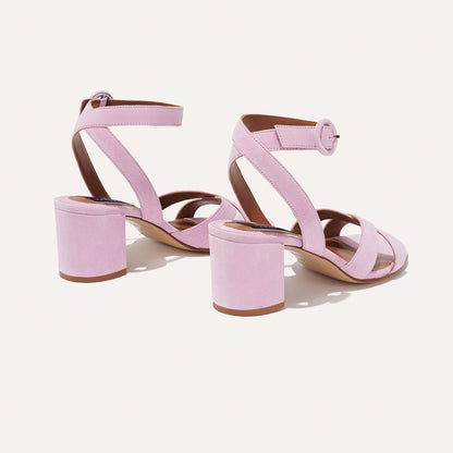 The City Sandal - Wisteria Suede by margaux-development features light pink suede, open toes, crisscross and ankle straps with round buckles, chunky block heels, and a cushioned insole for comfort—shown on a light background.